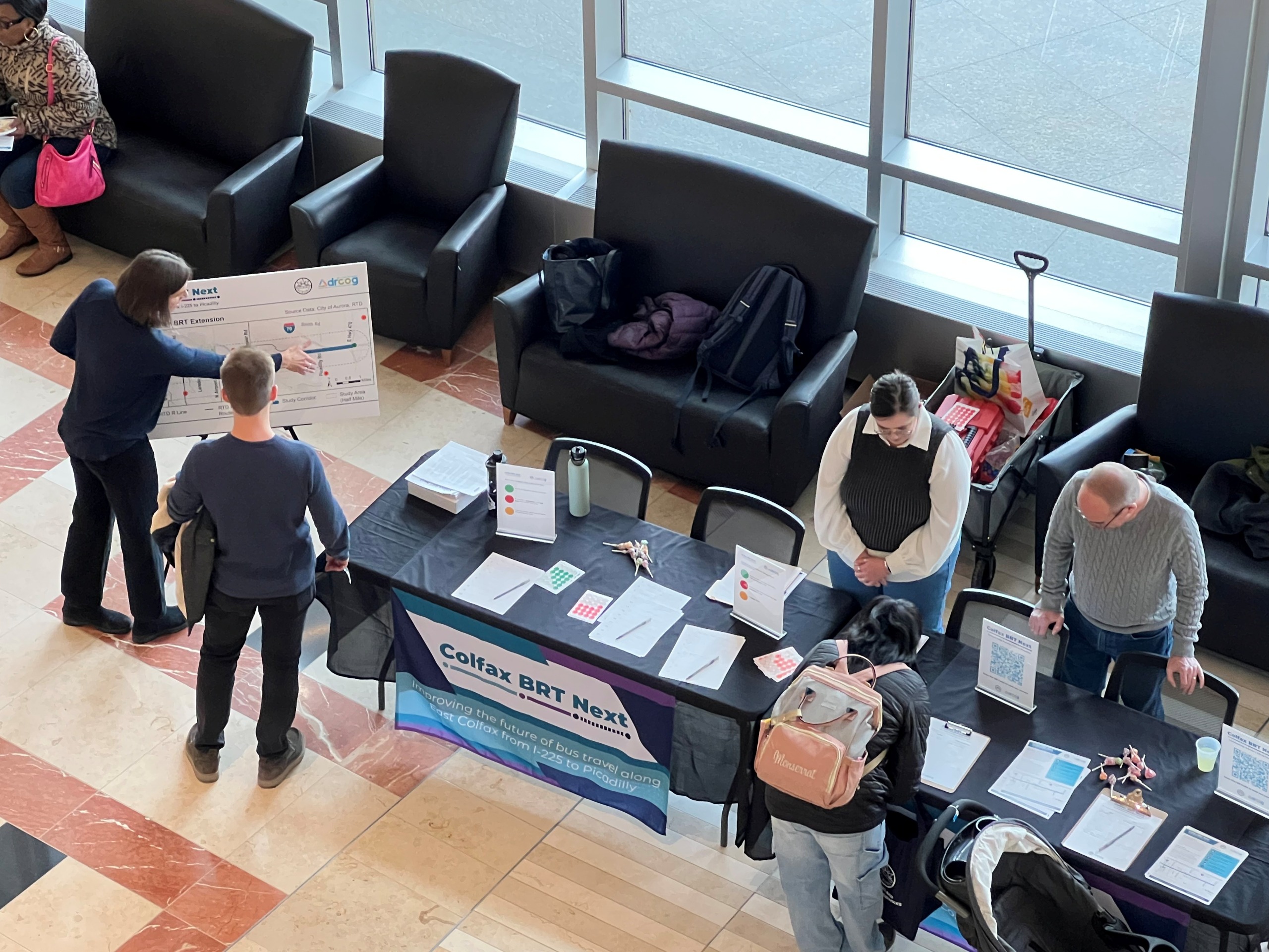 Six people standing around a Colfax BRT Next information table